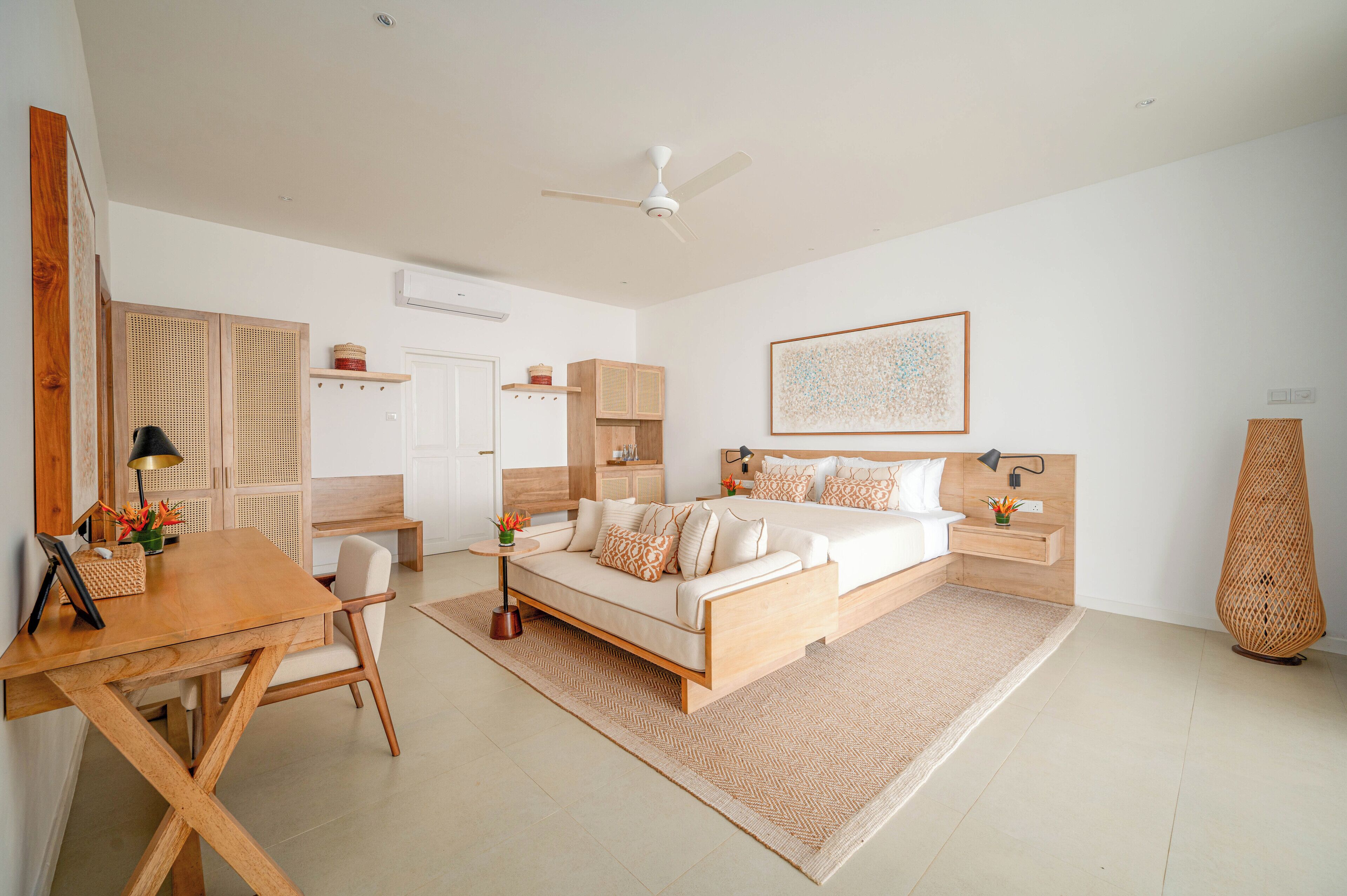 A modern bedroom with a bed, bedside tables, a desk, and a chair.