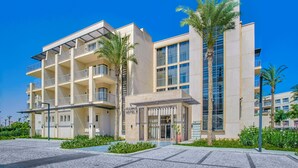 Un hôtel moderne à plusieurs étages, doté de balcons et d’une entrée principale avec un espace abrité.