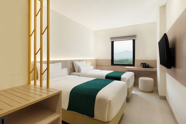 A hotel room with two beds, a TV, a window with a view, and a wooden shelf. - Elsotel Purwokerto by Daphna Management (Purwokerto)