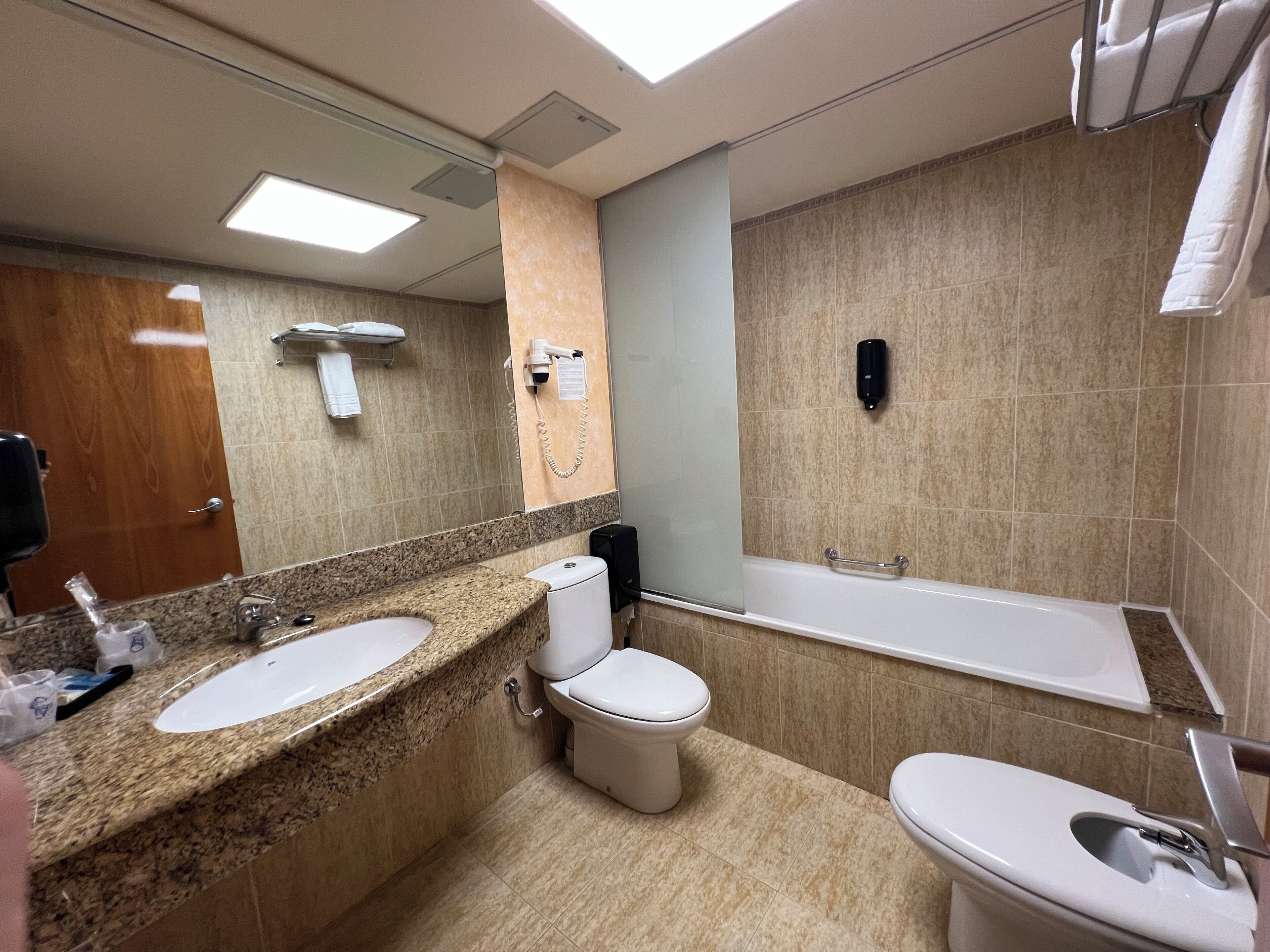 Un baño moderno con dos lavamanos, inodoro y bañera.