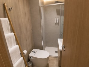 A modern bathroom with a toilet, shower, and towel rack. - Casa Violeta by Blossom Hotels. (Granada)