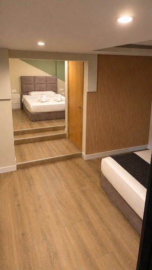Ein Schlafzimmer mit einem Bett, einer Holztür und einer Treppe, die zu einem anderen Raum führt.