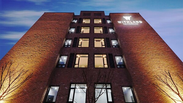 Un edificio alto de ladrillo con el letrero "WITHLAND" en la parte superior.