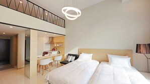 A modern hotel room with a large bed, a desk with chairs, and a kitchenette. - Withland Hotel Pyeongchang (Pyeongchang)