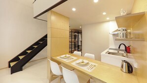 A modern kitchen with a dining area, a staircase, and a walk-in closet. - Withland Hotel Pyeongchang (Pyeongchang)