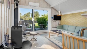 Una sala de estar moderna con chimenea, un sofá, una mesa de centro y un televisor montado en la pared.