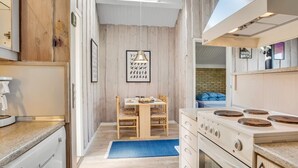 Una cocina compacta con una isla central, horno integrado y tragaluz.