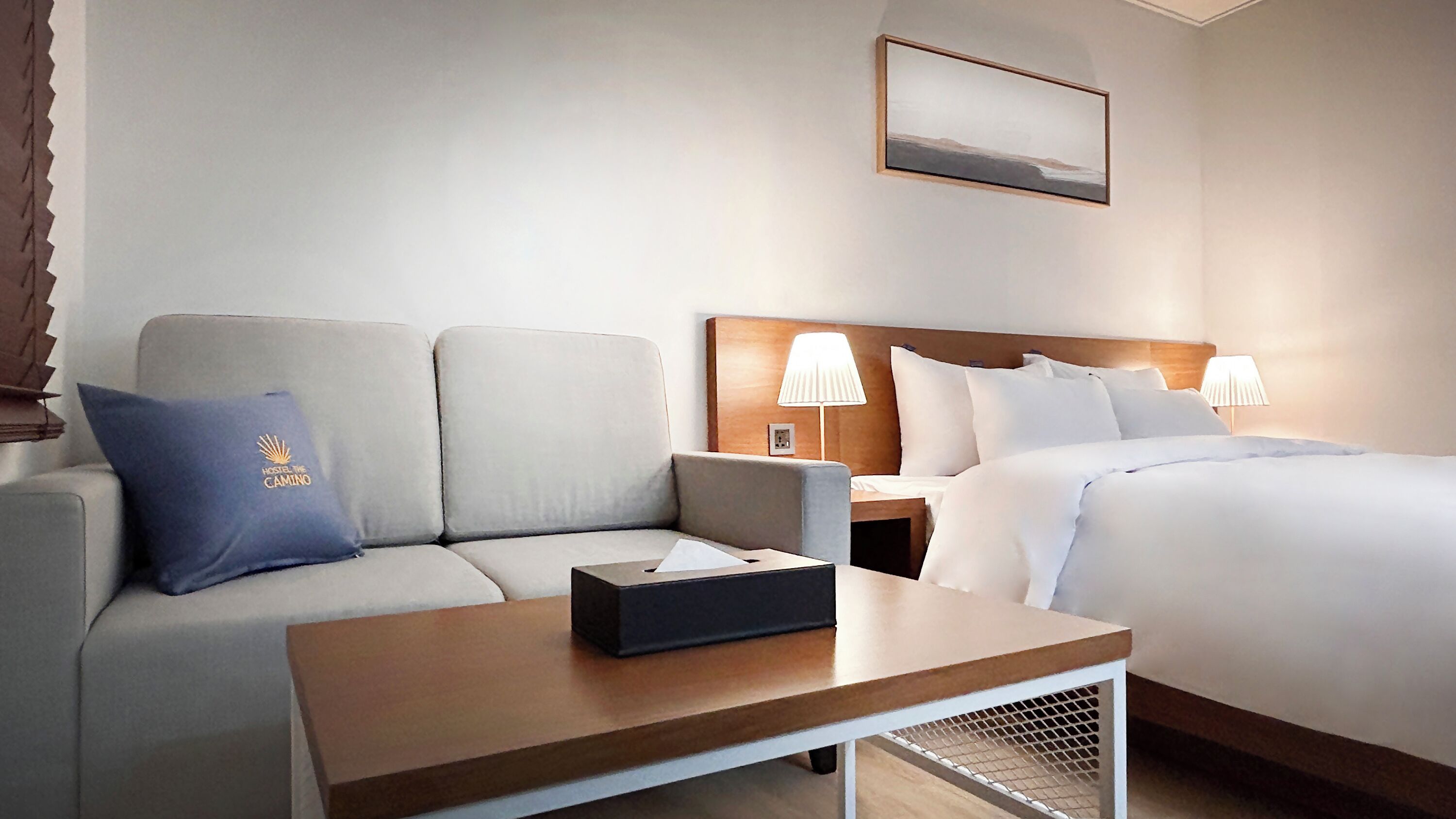 Une chambre d’hôtel avec un lit, un canapé, une table de chevet et une table.