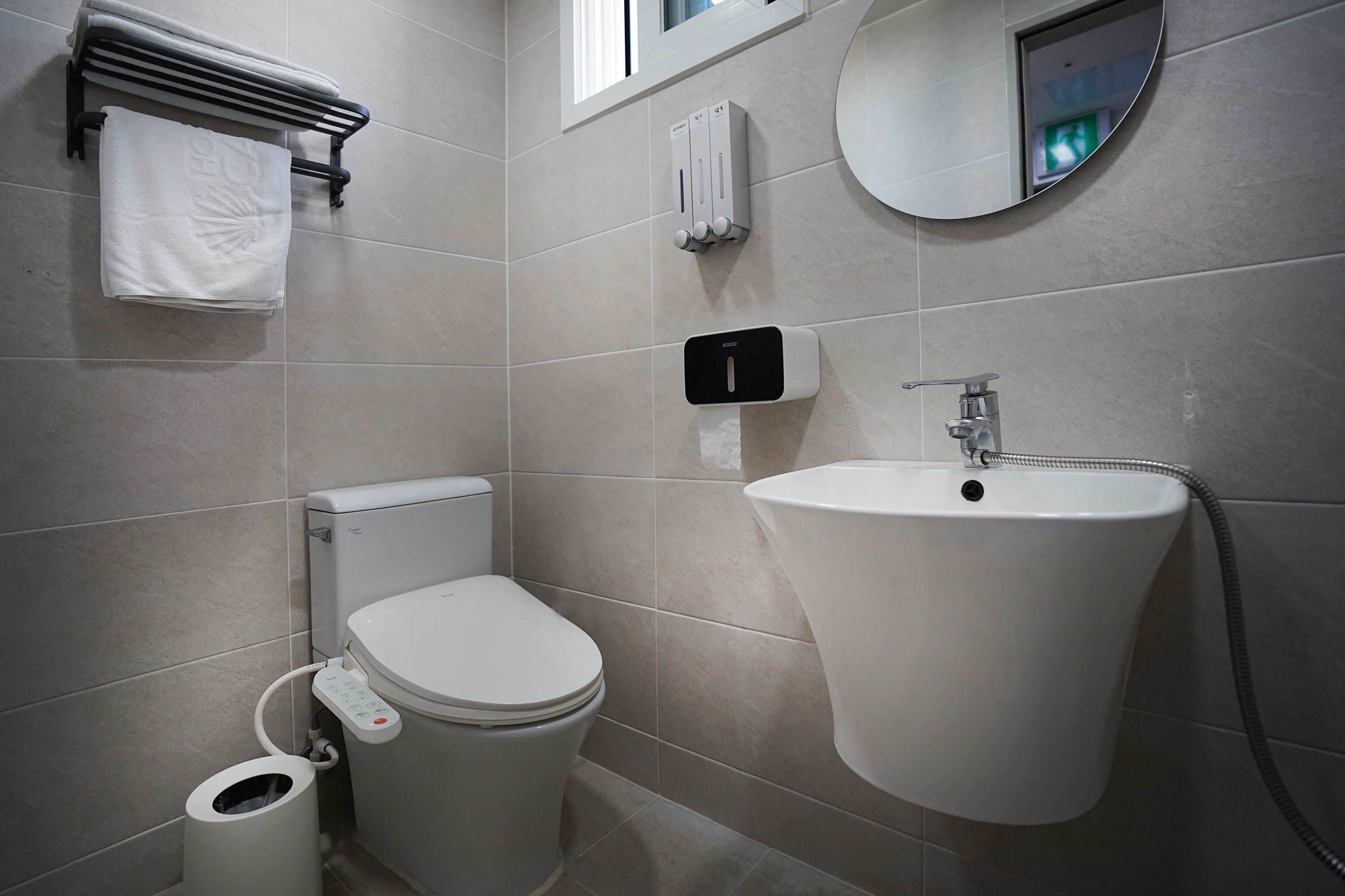 Un bagno moderno con WC, bidet e lavandino.