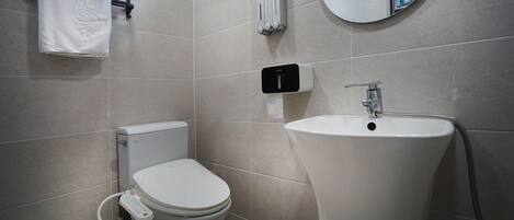 Un bagno moderno con WC, bidet e lavandino.