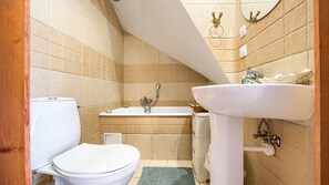 A bathroom with a toilet, bathtub, and sink.