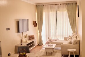 Deluxe Apartment, City View | Living area | TV - Sand Grains Residences 005 (Entebbe)