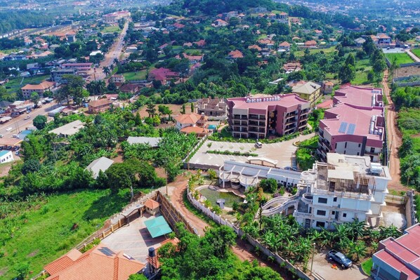 An aerial view of a residential area with multiple buildings, roads, and greenery. - Sand Grains Residences 005 (Entebbe)