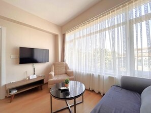 Familiesuite, delvis sjøutsikt | Oppholdsområde | En 40-tommers smart-TV med Parabol-TV samt Netflix og Hulu