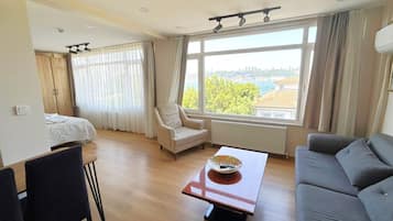 Suite Deluxe, vista al mar | Área de sala de estar | Televisión LED de 40 pulgadas con canales vía satélite