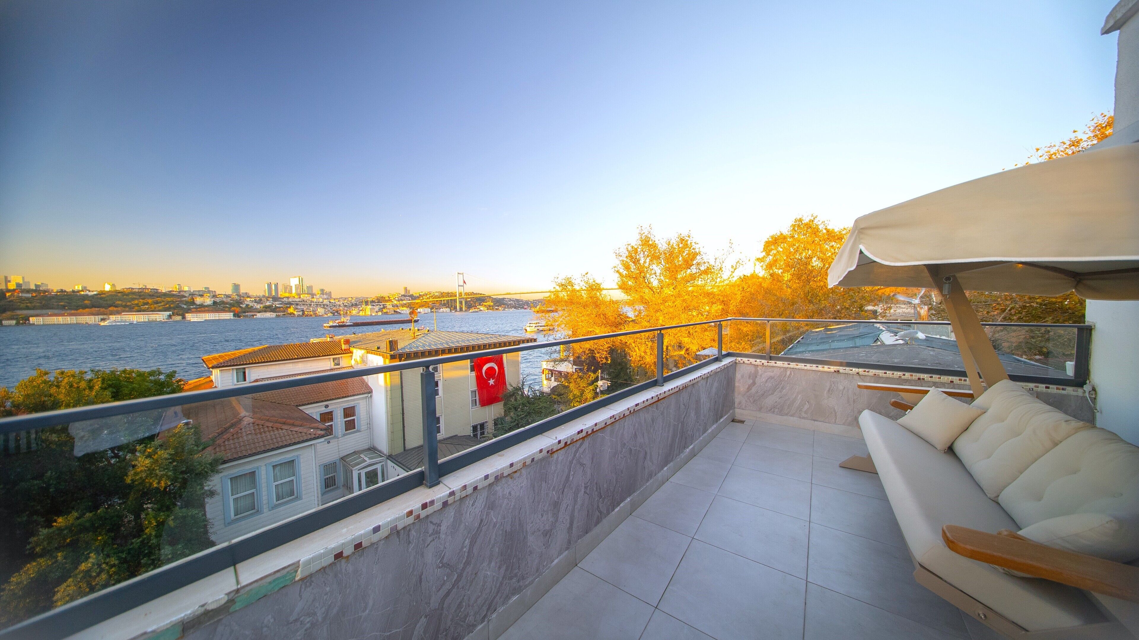 A balcony with a view of a river and cityscape.