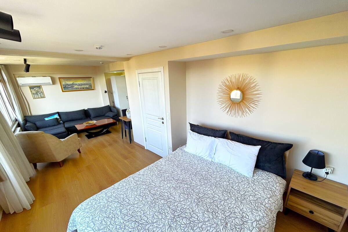 Une chambre d’hôtel avec un grand lit, un canapé, une petite table et une table de chevet.