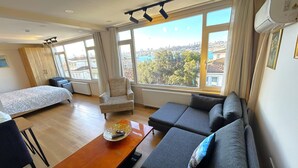 Une chambre d’hôtel moderne, équipée d’un canapé, d’un fauteuil et d’un lit.