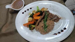 A plate with beef, carrots, and broccoli, and a small bowl of sauce. - Coconut Garden Garden Cafe (Mae Sai)