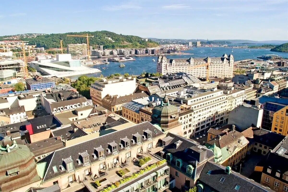 Paesaggio urbano con un edificio storico ben visibile con una cupola, circondato da architettura moderna e un fiume.