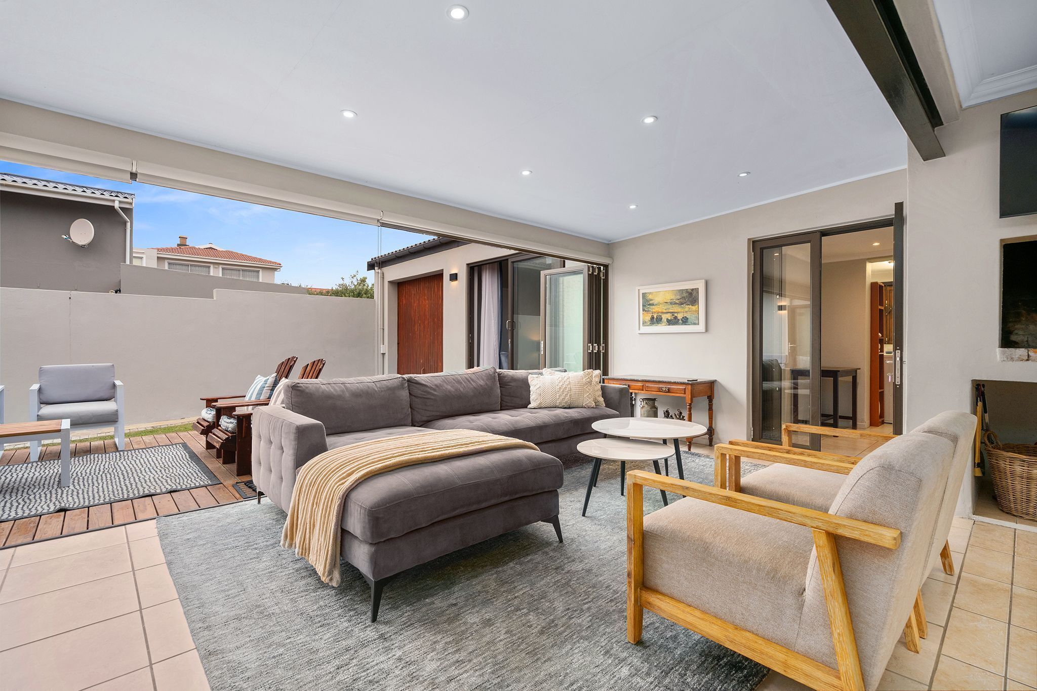 Una sala de estar moderna con sofá, sillones, una mesa de centro y chimenea.