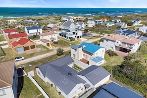 A residential area with houses, a swimming pool, and a view of the ocean. - 8 on Nivenia (Betty's Bay)