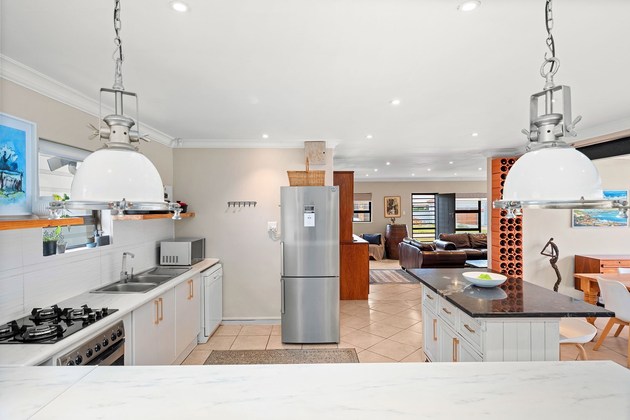 A modern kitchen with a central island, stainless steel appliances, and pendant lighting.