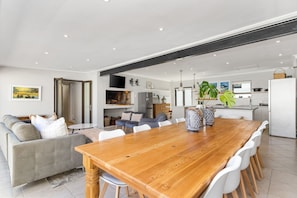 A modern living space with a dining area, kitchen, and seating area. - 8 on Nivenia (Betty's Bay)