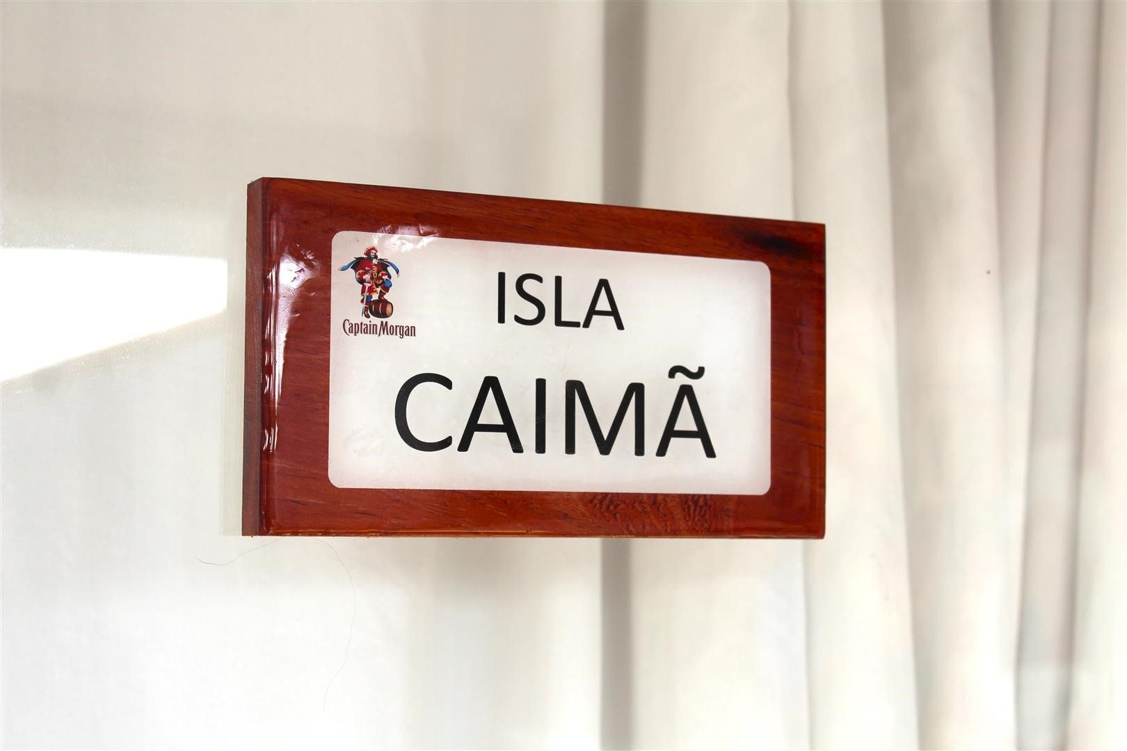 A sign with the text 'ISLA CAIMÃ' and a logo of Captain Morgan.