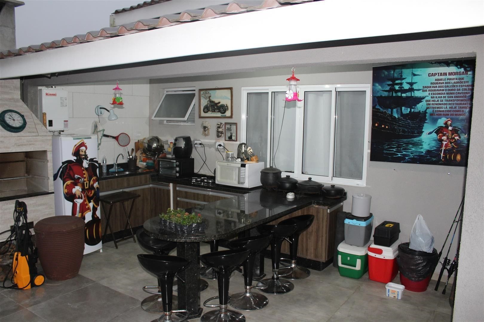 Una cocina con barra, refrigerador, microondas y un cartel en la pared.