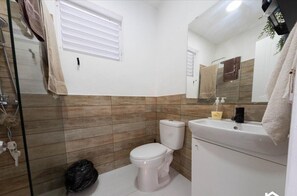 A bathroom with a toilet, sink, and shower area. - Tropical Paradise Villa (Sosúa)