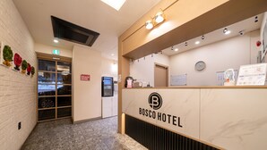 A reception desk with a sign reading "BOSCO HOTEL" and a "SNACK ZONE" sign. - Hotel Bosco Incheon (Incheon)