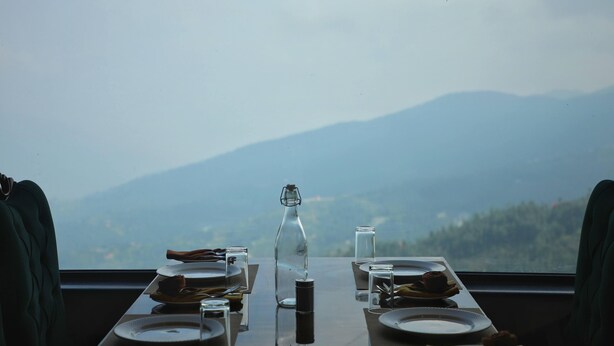 Une table dressée pour deux personnes, avec vue sur la montagne.