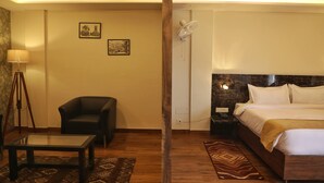Une chambre d’hôtel comprenant un lit, une chaise, une table et deux œuvres d’art accrochées au mur.