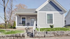 A single-story house with a front porch, a small front yard, and a stone retaining wall.