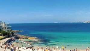 A coastal beach with a cityscape in the background.