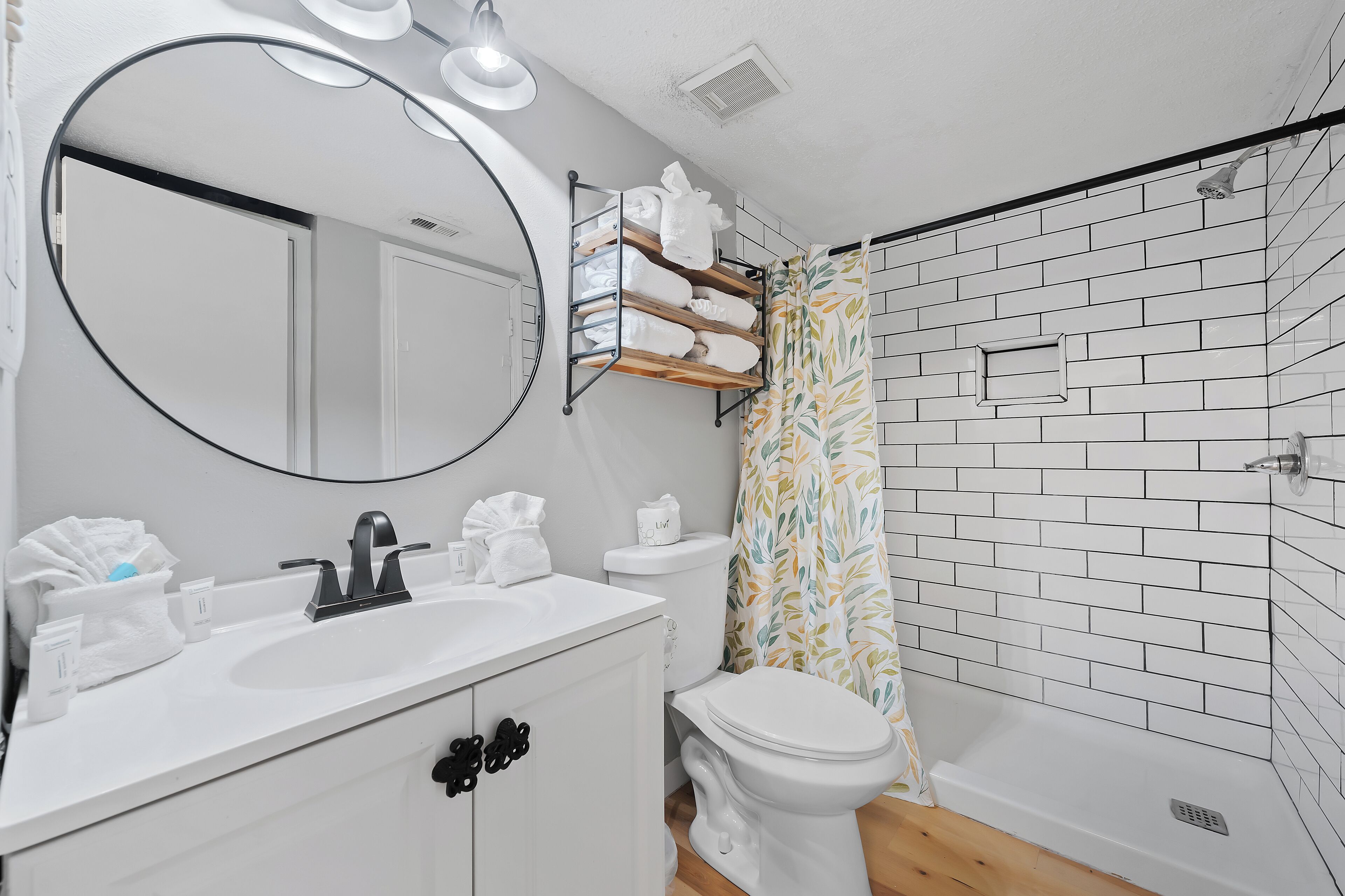 Un baño moderno con lavamanos blanco, inodoro y zona de ducha.