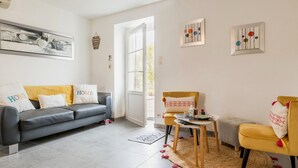 Un soggiorno moderno con un divano grigio, una poltrona gialla e un tavolino rotondo.