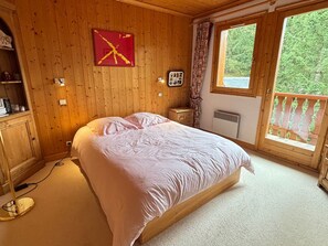 Relax in this serene bedroom with a single bed, bedside table, and a large window offering a view of lush greenery.