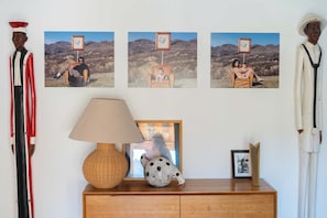 Guests can enjoy a warm and inviting space with a wooden cabinet, a woven lamp, and a framed photograph.