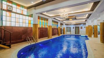 Una piscina techada, sillones reclinables de piscina