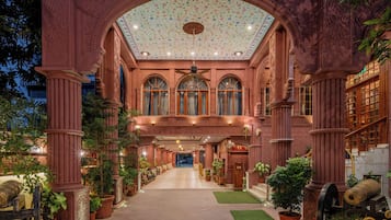 An ornate building with a central hallway, large windows, and a decorative ceiling.