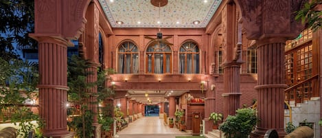 An ornate building with a central hallway, large windows, and a decorative ceiling.