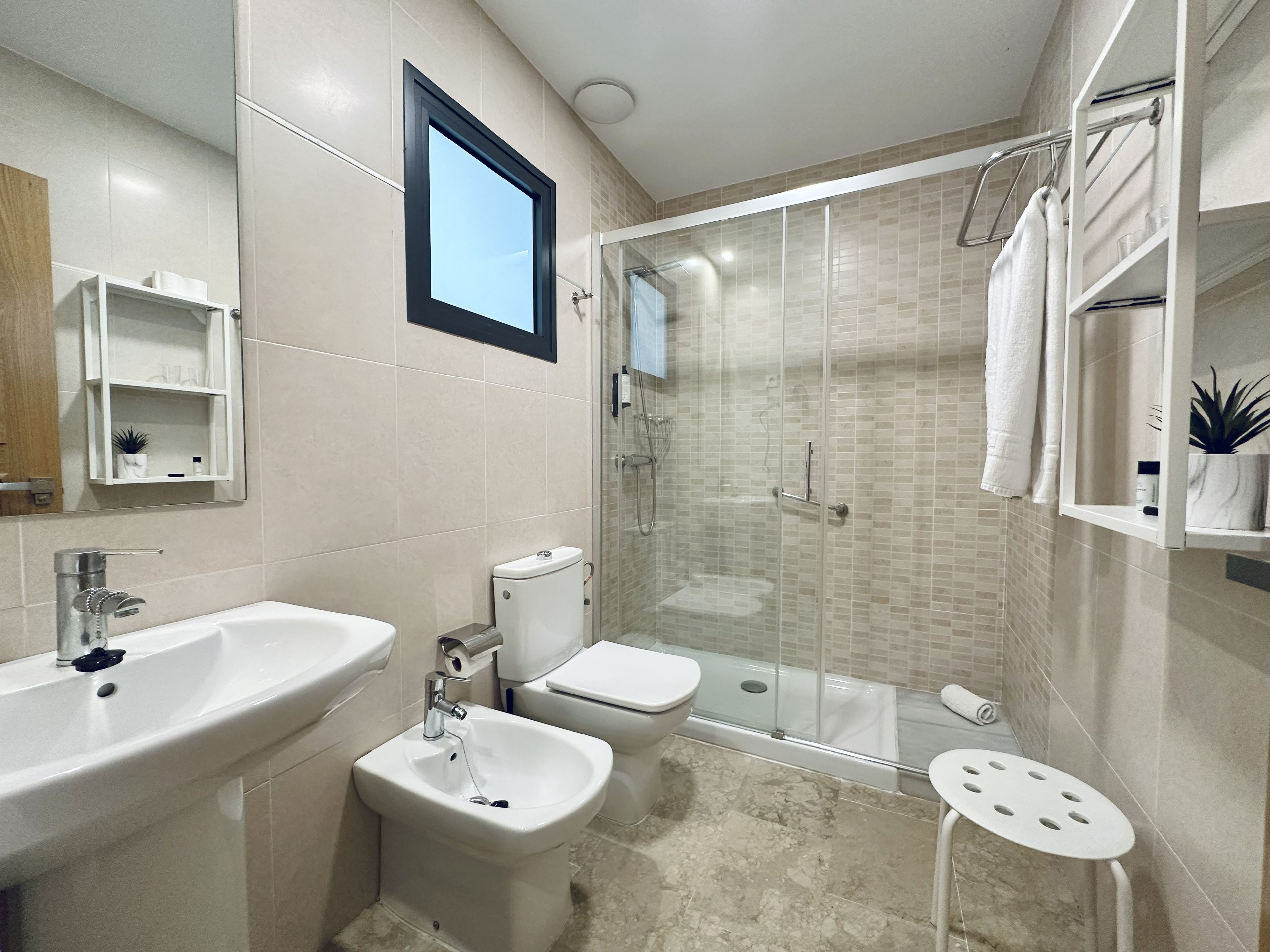 Un baño moderno con bañera, ducha y bidé. Hay un lavabo y un espejo encima.