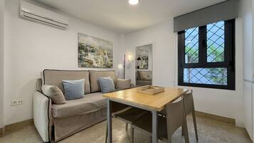 Una sala de estar moderna con sofá, mesa de comedor y ventana con vistas.