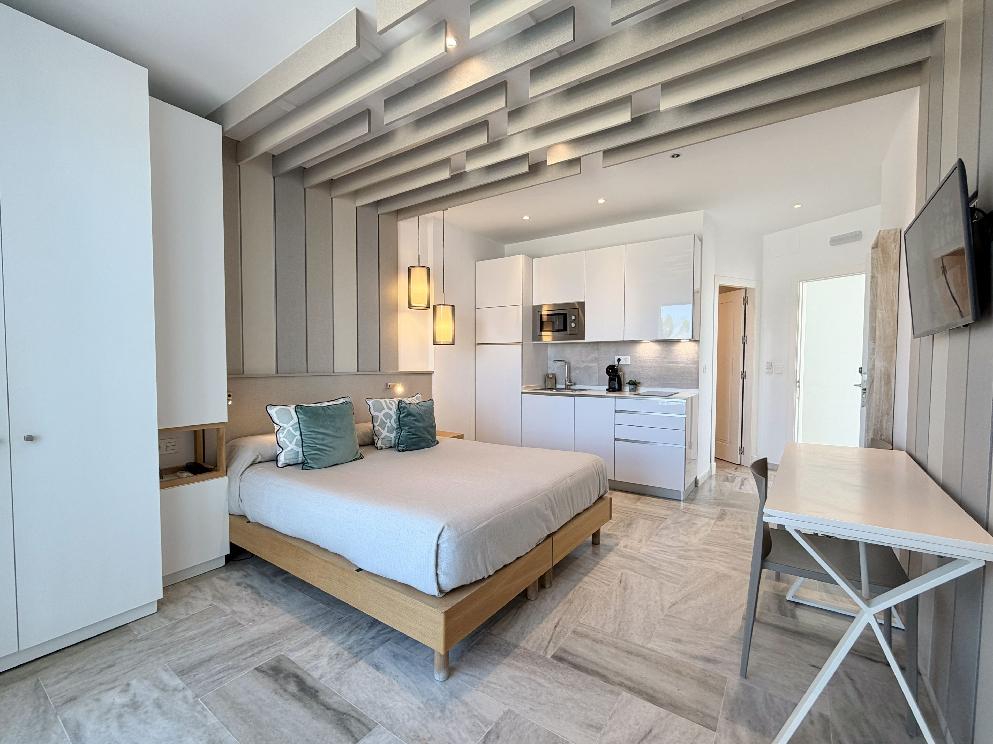 A modern bedroom with a bed, bedside tables, and a built-in wardrobe.