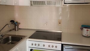 A kitchen with white cabinets, a microwave, a stove, and a washing machine. - Bright and centrally located with views. Wifi and TV. Ski resorts nearby. (Jaca)