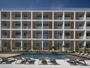 A modern multi-story hotel with balconies, a swimming pool, and lounge chairs. - Mercure Ponta Delgada Azores (Ponta Delgada)