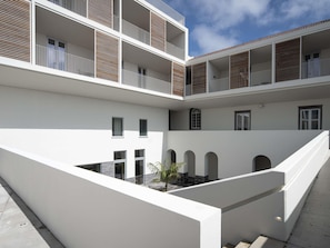 A multi-story building with balconies, a courtyard, and a staircase.