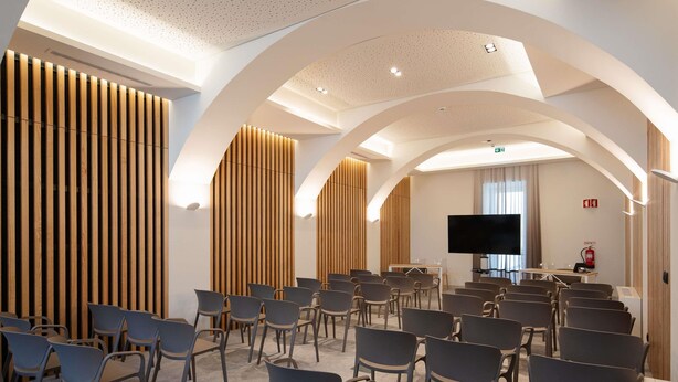 A conference room with rows of chairs, a large flat-screen TV, and wooden panel walls. - Mercure Ponta Delgada Azores (Ponta Delgada)